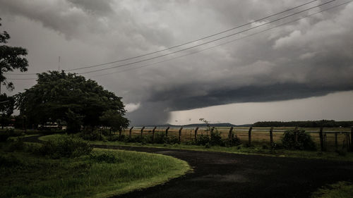 Road amidst field against sky