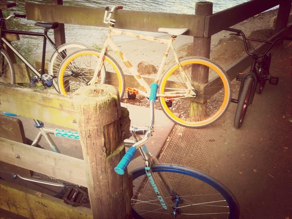 bicycle, mode of transport, transportation, land vehicle, stationary, parked, parking, wheel, railing, day, sunlight, outdoors, cycle, leaning, travel, blue, street, no people, part of, high angle view