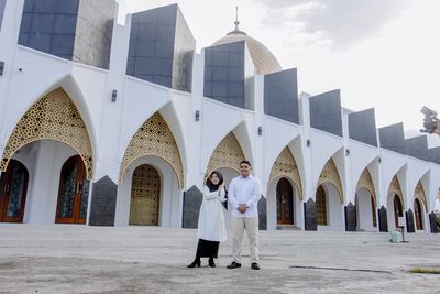 People standing outside temple against building