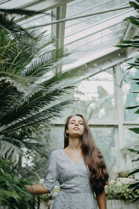 Front view of a young woman amidst plants