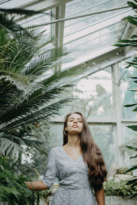 Portrait of woman standing against plants