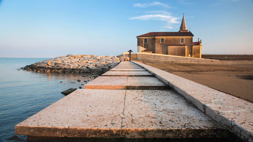 Building by sea against sky