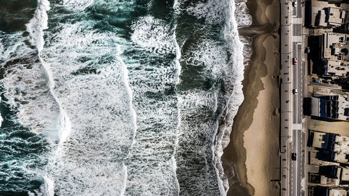 High angle view of waves splashing on beach