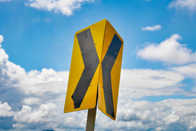 Low angle view of road sign against sky