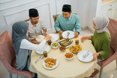 Male friends with food on table