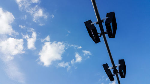 Low angle view of stoplight against blue sky