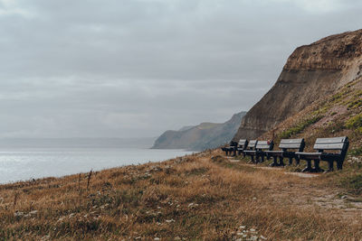 Row of benches along the coastal walk on jurassic coast, a world heritage site in south england.