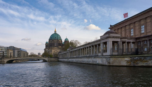 Arch bridge over river against buildings in city