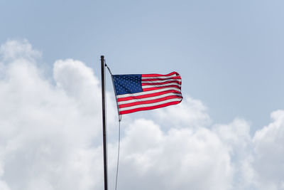 Low angle view of flag against blue sky