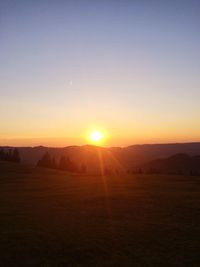 Scenic view of field against clear sky during sunset