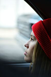 Side view of young woman in car