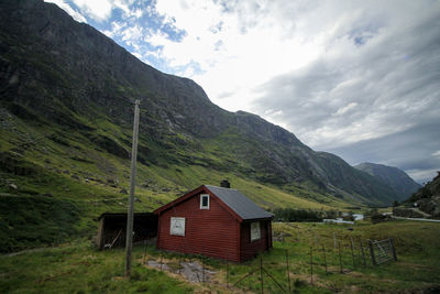 Scenic view of house and mountains against sky