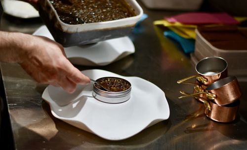Midsection of person holding coffee cup on table