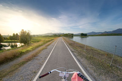 Road by river against sky