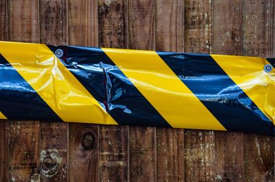 Close-up of flag against wooden wall