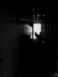 Silhouette people walking in corridor of building