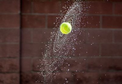 Close-up of tennis ball splashing water 