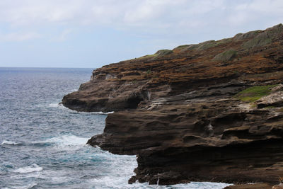 Rock formations by sea against sky