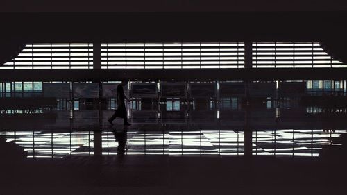 Silhouette of people walking at railroad station