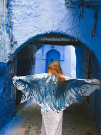 Rear view of woman standing at archway