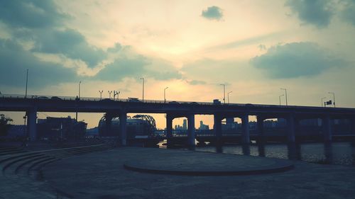 Bridge over river against sky in city