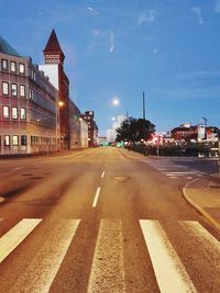 View of city street and buildings at dusk