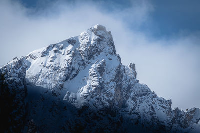 Low angle view of snowcapped mountains against sky