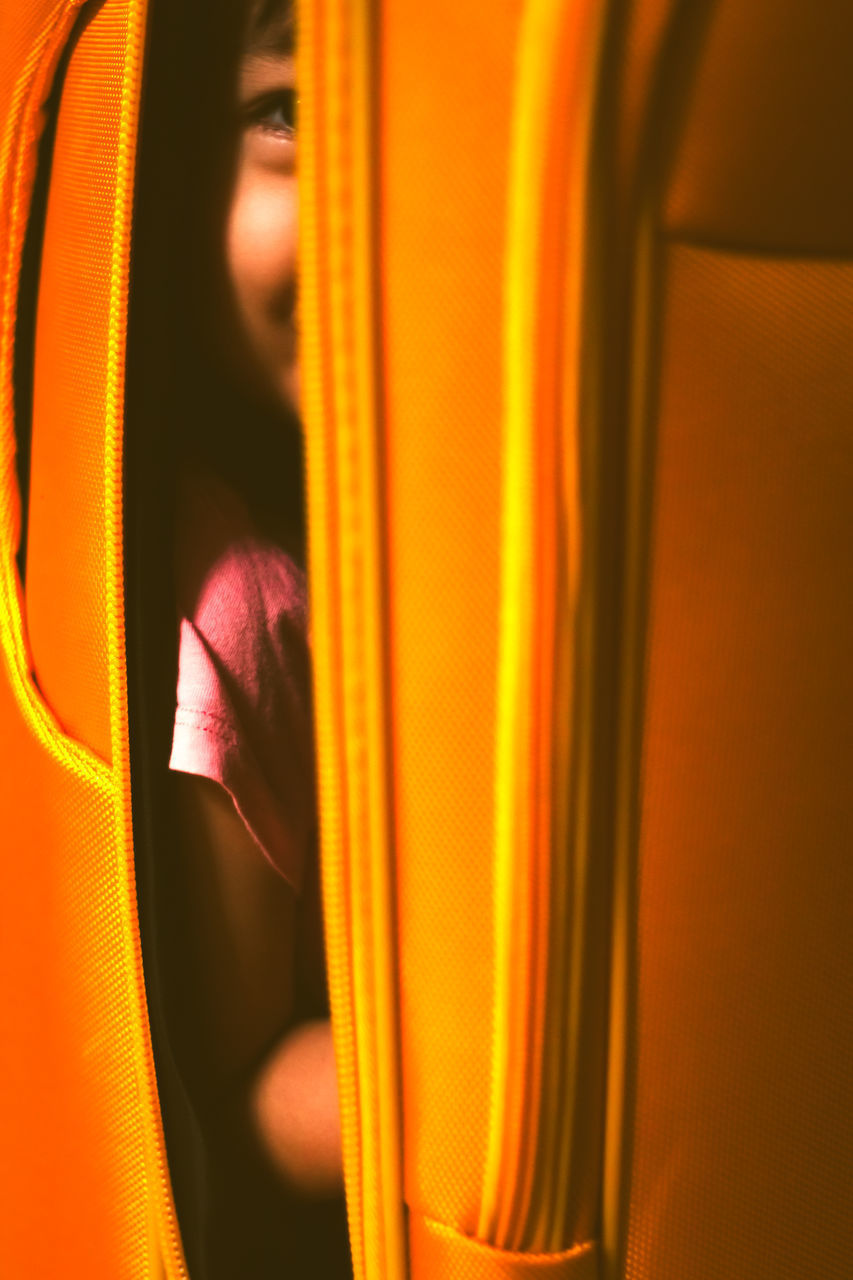 CLOSE-UP PORTRAIT OF WOMAN STANDING AGAINST YELLOW WINDOW