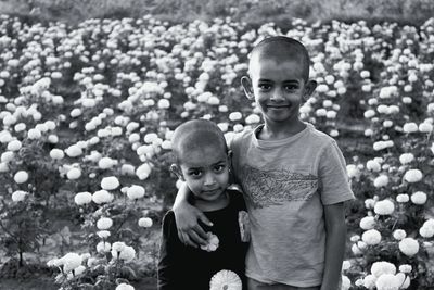 Portrait of siblings standing amidst flowers
