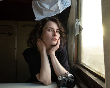 Portrait of young woman using mobile phone while sitting at home