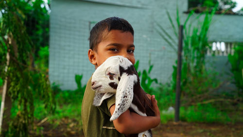 Indian little boy holding the small goat. friendship of child and yeanling, image toned