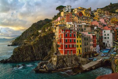 Buildings by sea against sky