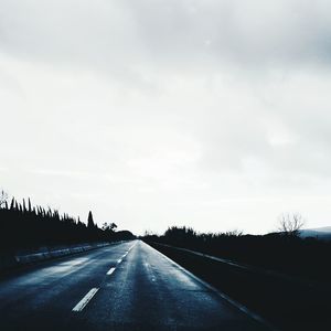 Empty road against cloudy sky