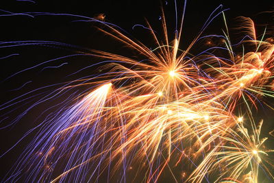 Low angle view of firework display at night