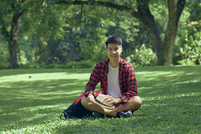 Young man sitting on grass