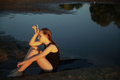 Teenage girl sitting by lake
