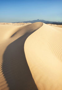 Sand dunes in desert against sky