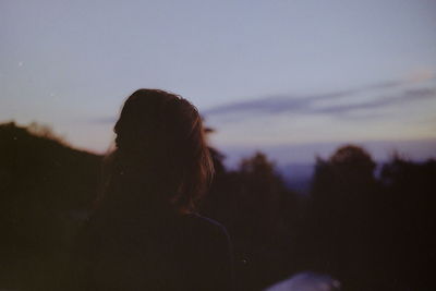 Rear view of woman against sky during sunset