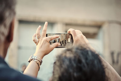 Close-up of woman using mobile phone for a picture of a street band