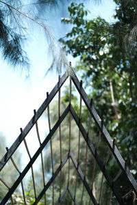 Low angle view of metal fence against sky