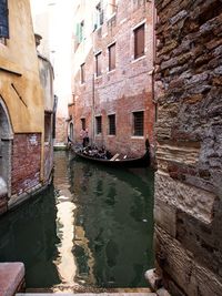 View of boat in canal passing through buildings