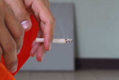 Close-up of hand holding cigarette