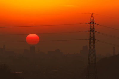 Scenic view of power lines against sky during sunset