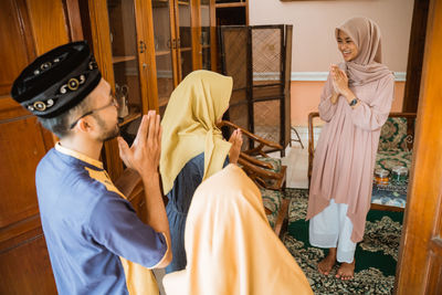 Happy woman receiving guests at home