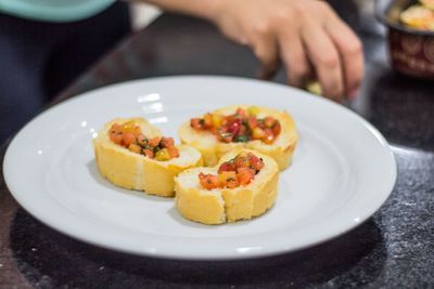 Close-up of hand holding dessert served on table