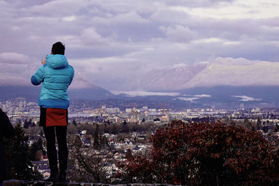 Rear view of a woman overlooking townscape