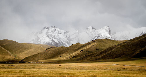 Scenic view of landscape against snowcapped mountains 