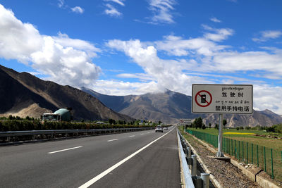Road sign against sky