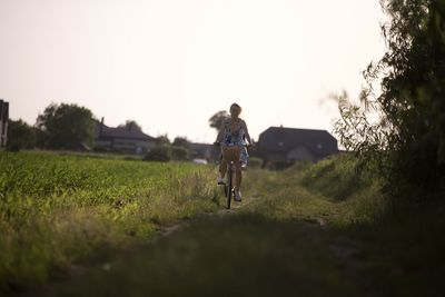 Rear view of woman walking on field