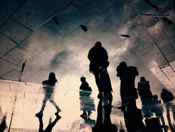 High angle view of silhouette people walking on wet road